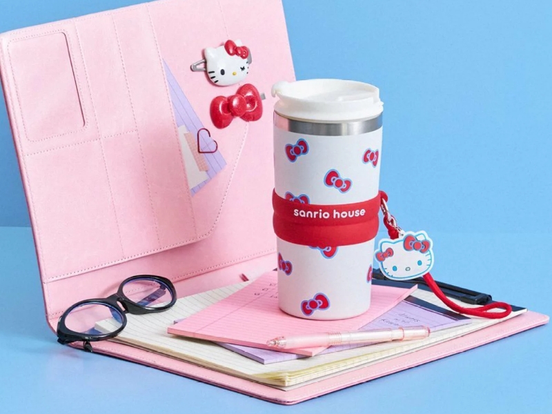 Sanrio Hello Kitty 600ml stainless steel vacuum insulated tumbler featuring full ribbon pattern, silicone band, and logo charm.