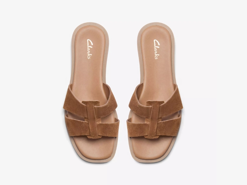 Clarks Trala Slide flat sandals in tan suede, featuring a modern square toe and a flexible sole.
