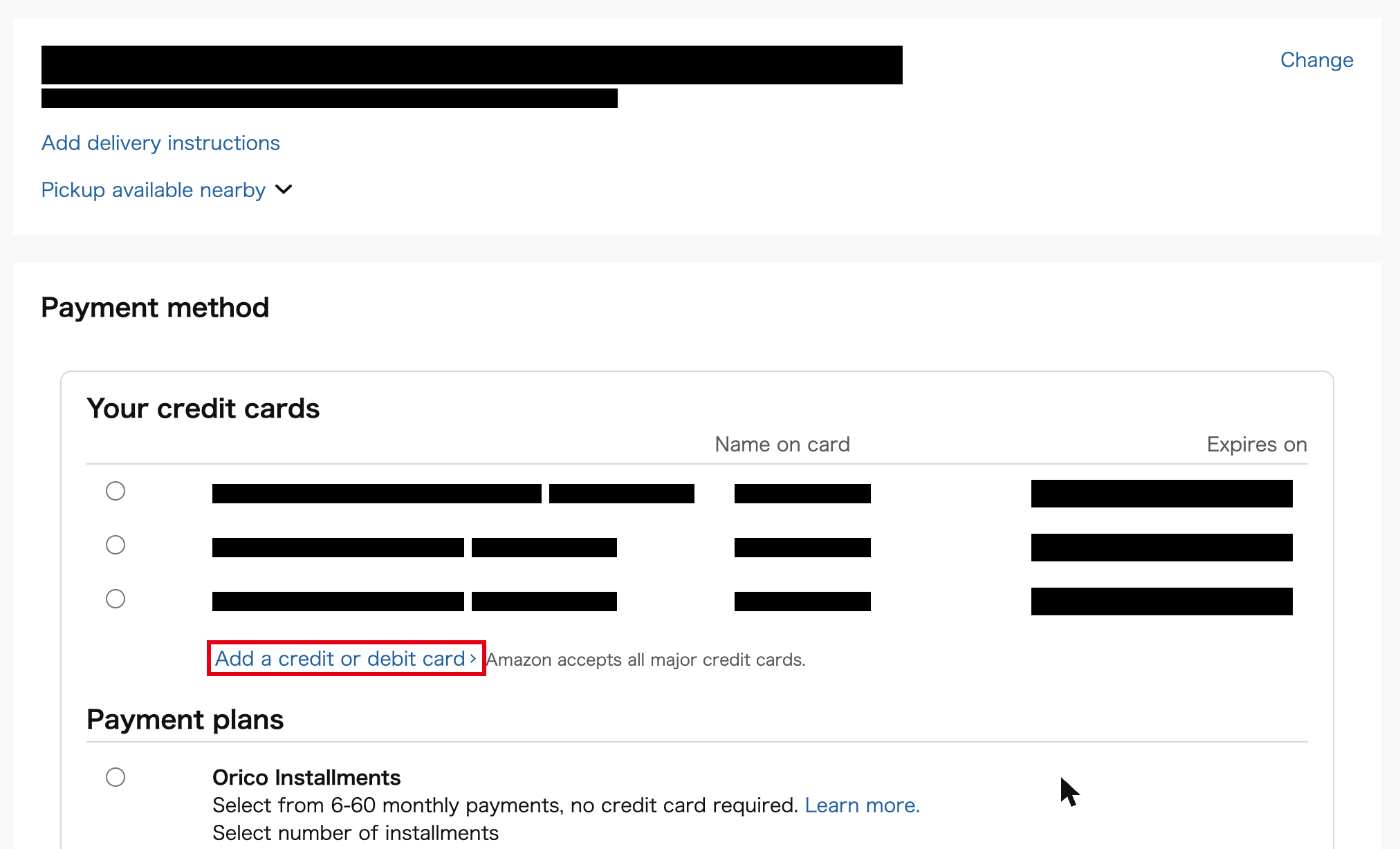 Amazon.co.jp checkout payment method page with the Add a credit or debit card link highlighted